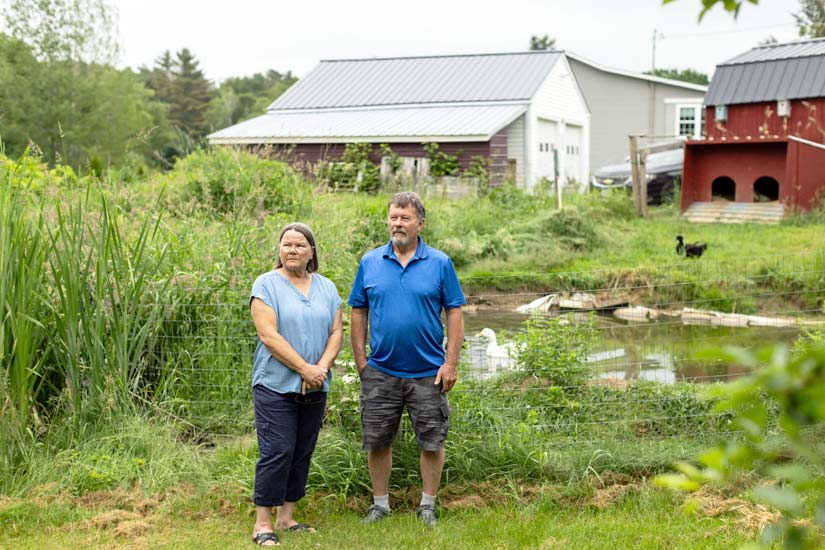 couple standing in front of house farm