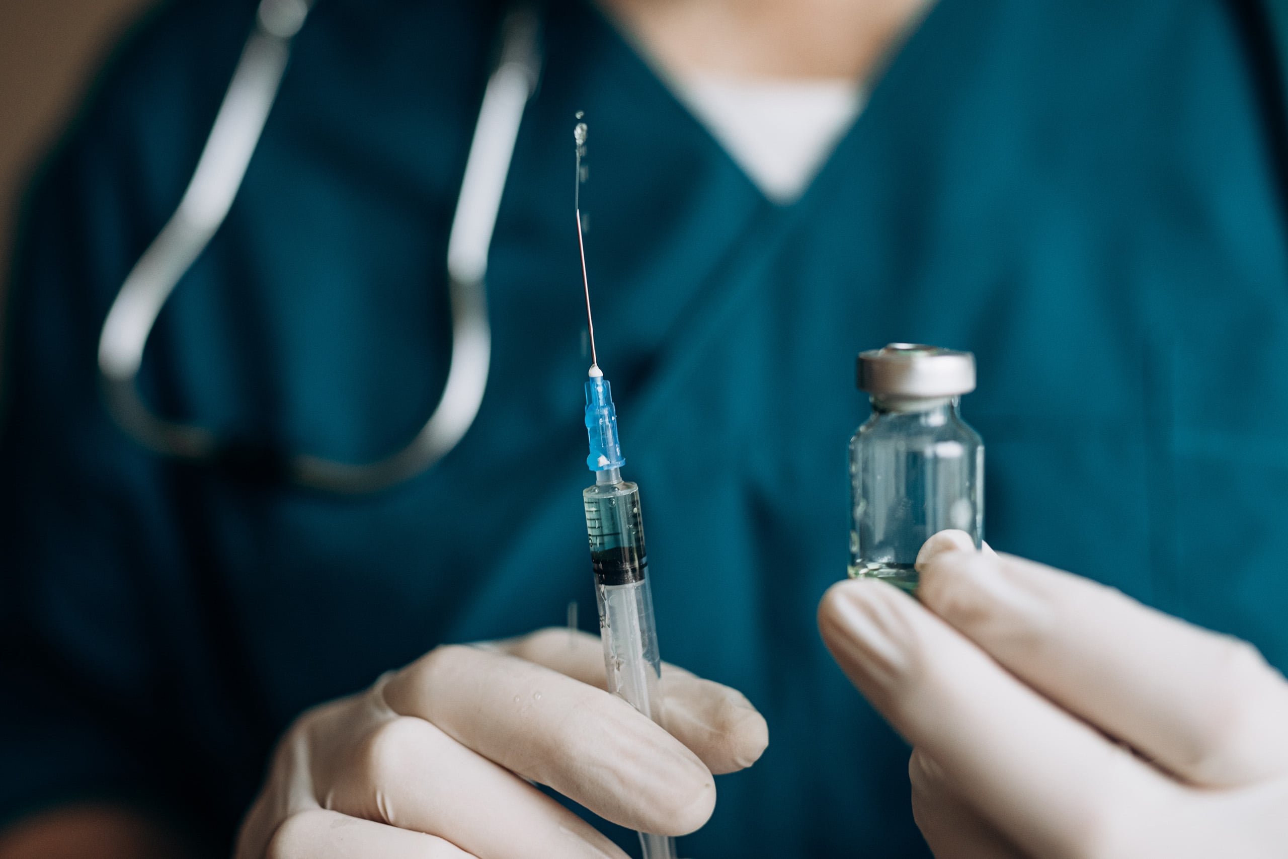Doctor holding a needle and vaccine vile.