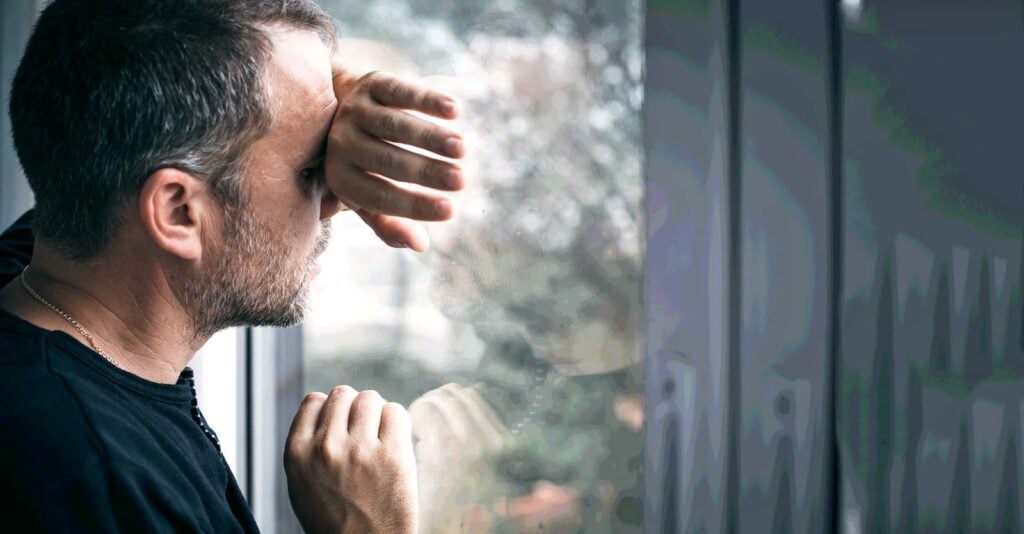 adult man looking out window
