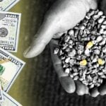 hand holding corn seeds and money