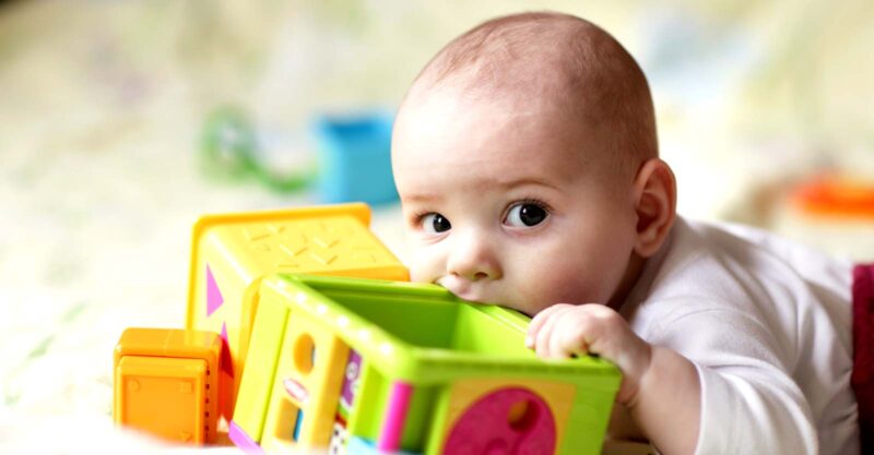 baby chewing on toys