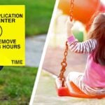 pesticide application lawn sign and young girl on swing at playground