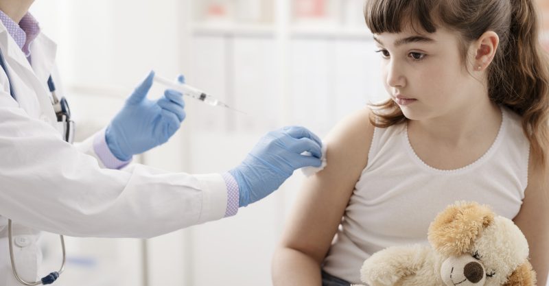 Female doctor giving an injection to a young girl