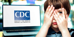 laptop with cdc logo on it and boy covering one eye