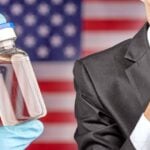 vaccine bottle and person giving the quiet sign