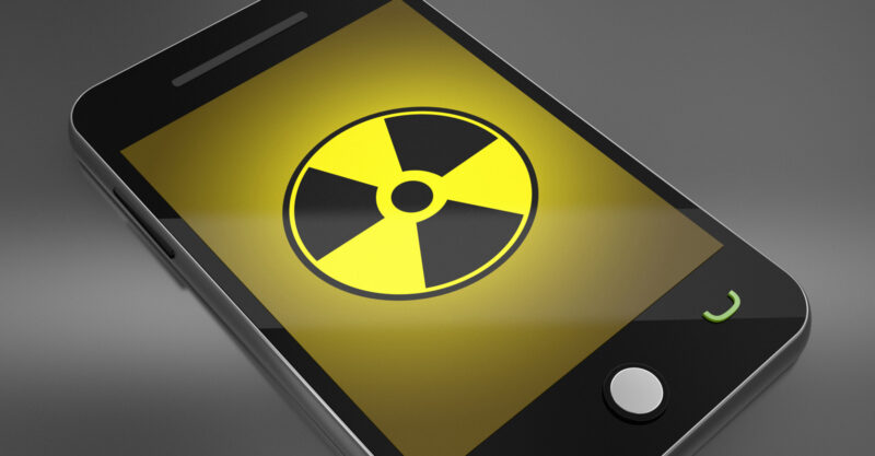 Graphic of smart phone with radiation warning symbol on the screen.