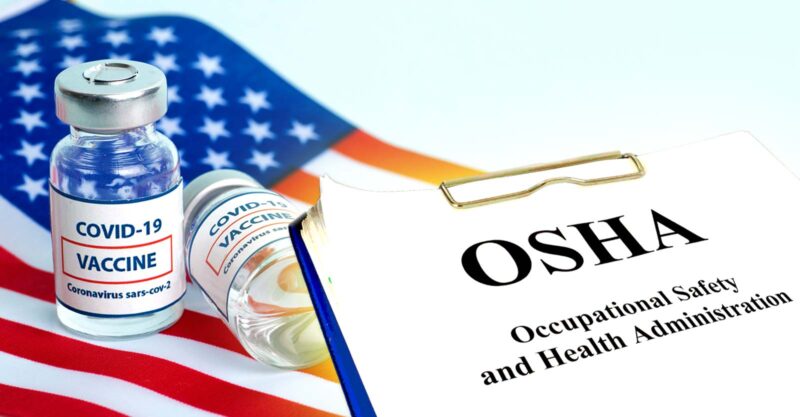 covid vaccine and letters "OSHA" on clipboard