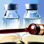 vaccine bottles with gavel on book