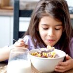 young girl eating bowl of cereal
