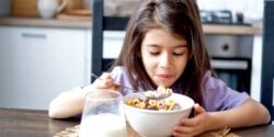 young girl eating bowl of cereal
