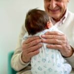 grandparent with newborn and vaccine bottle