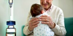 grandparent with newborn and vaccine bottle