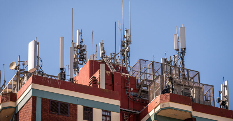 Photo of multiple cellular antennas installed on roof of residential building.
