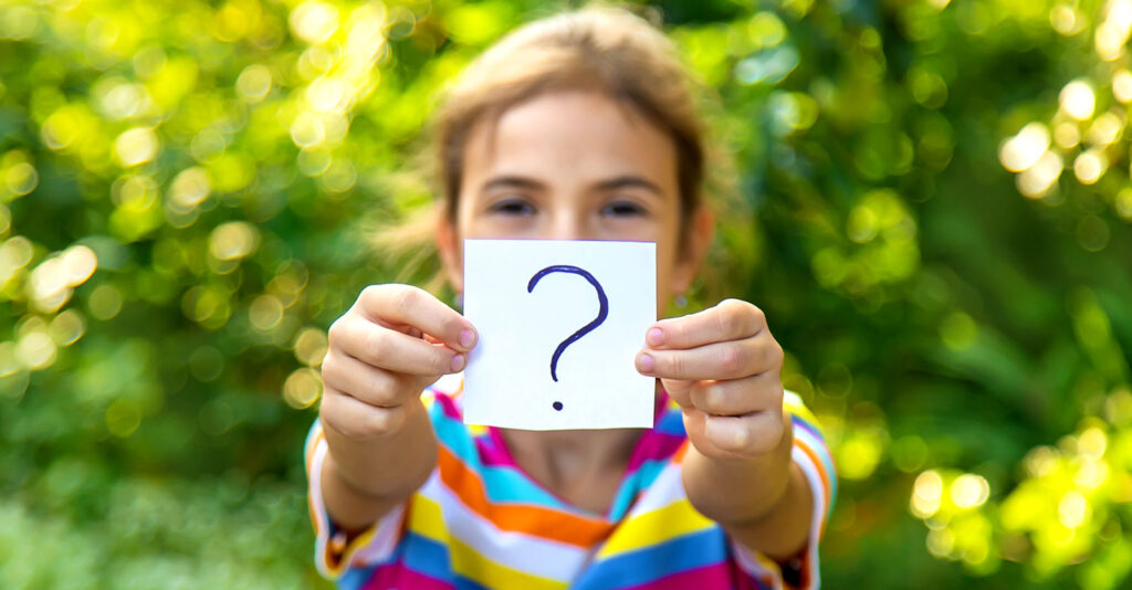 girl holding paper with question mark