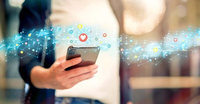 woman holding cell phone and social media icons
