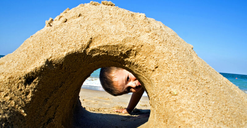 child and sand castle