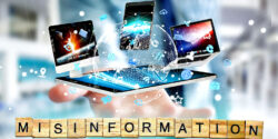 misinformation and hand holding phone and computer