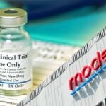 clinical trial vaccine bottle and moderna logo on building