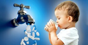 pills coming out of water faucet and toddler drinking cup of water