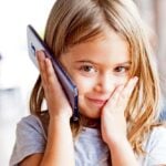 young girl holding cellphone to ear