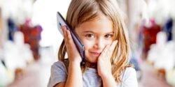 young girl holding cellphone to ear
