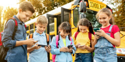 school bus with kids using cellphones