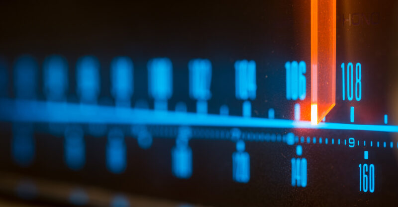 Classic radio tuner panel close-up. Black background