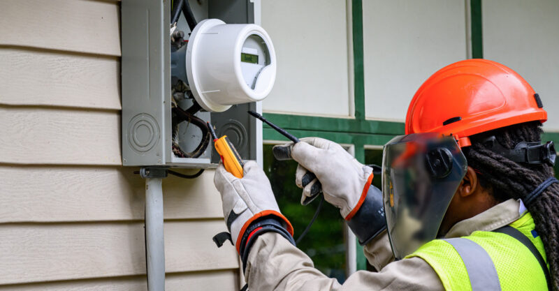 An electrical technician removes the old Power Meter and replaces it with a new Smart Meter