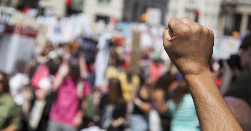 Person's raised first in front of a live protest
