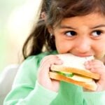 young girl eating sandwich