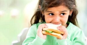 young girl eating sandwich