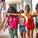 school kids and vaccine bottle