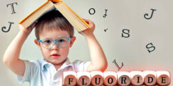 boy holding book over his head and word "fluoride"