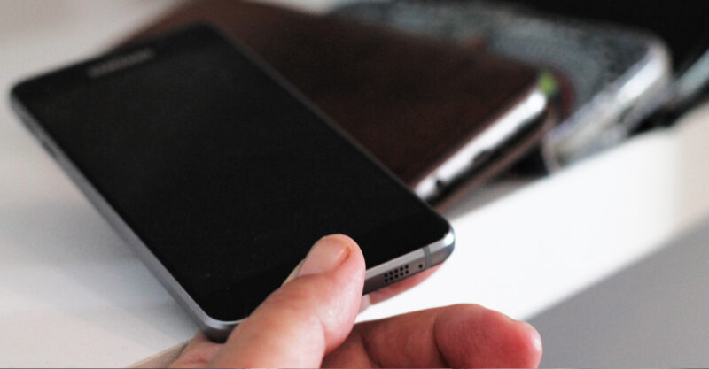 Putting mobile or cell phone away by placing it at a shelf with other phones