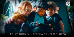 3 young kids looking down at a tablet screen