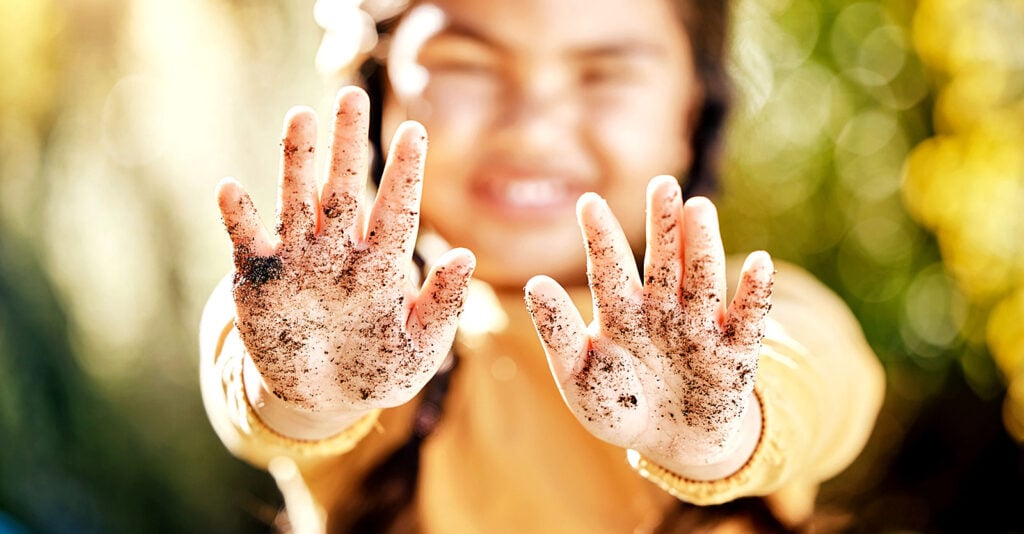 girl showing dirt on hands