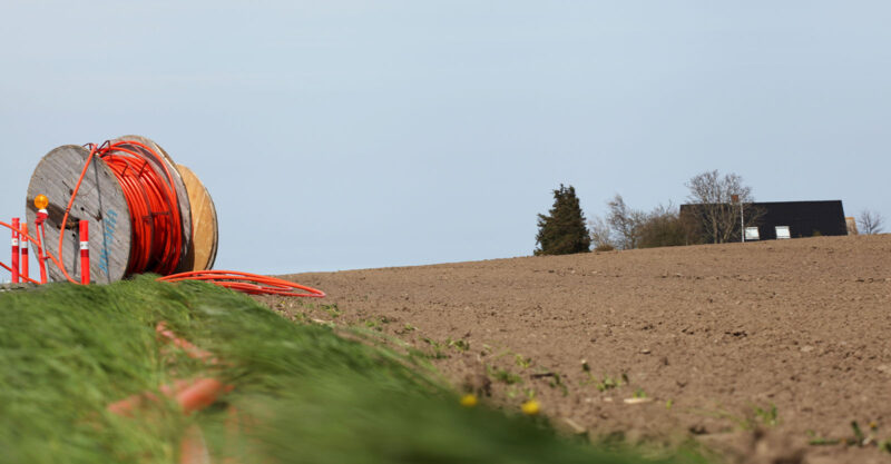 Large roll of broadband wire on the side of the road being installed.
