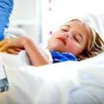 child in hospital and flu vaccine bottle