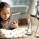 young child on tablet and lady justice