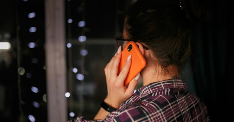Woman holding cell phone to her ear.