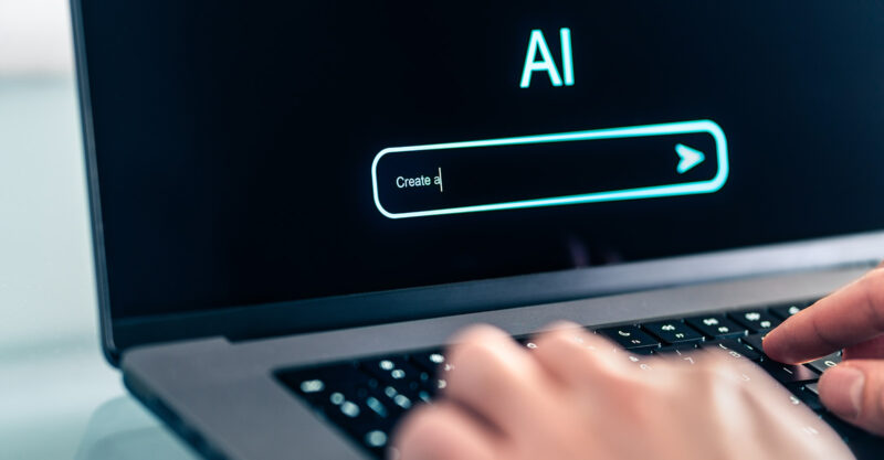 Person using AI prompt chat bot on laptop computer.