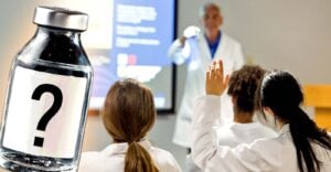 doctor teaching medical students and vaccine bottle
