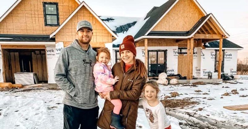Meredith family in front of their house during construction