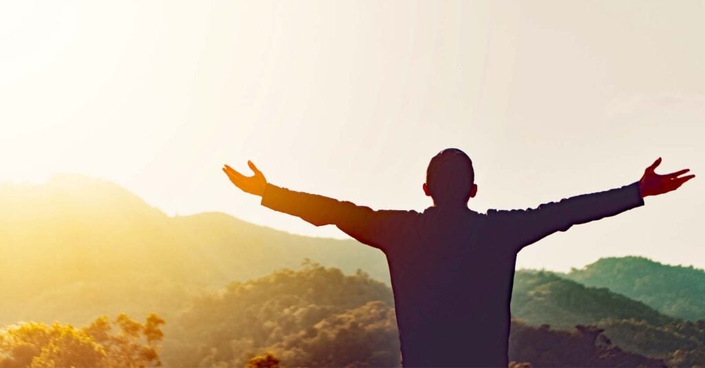 man standing with arms out