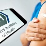 nih logo and bandage over vaccine site on a person's arm