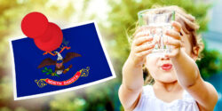 girl holding glass of water and north dakota flag
