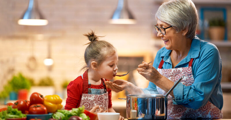 grandma teaching granddaughter how to cook