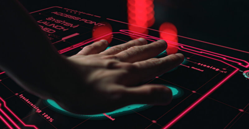 Person's hand on a digital hand / palm scanner.