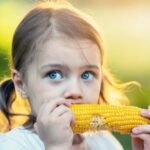 girl eating corn on the cobb