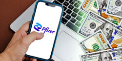 pfizer logo on phone with money